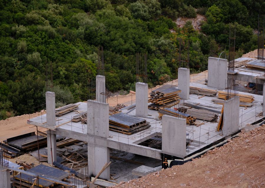 Hillside home under construction surrounded by forest